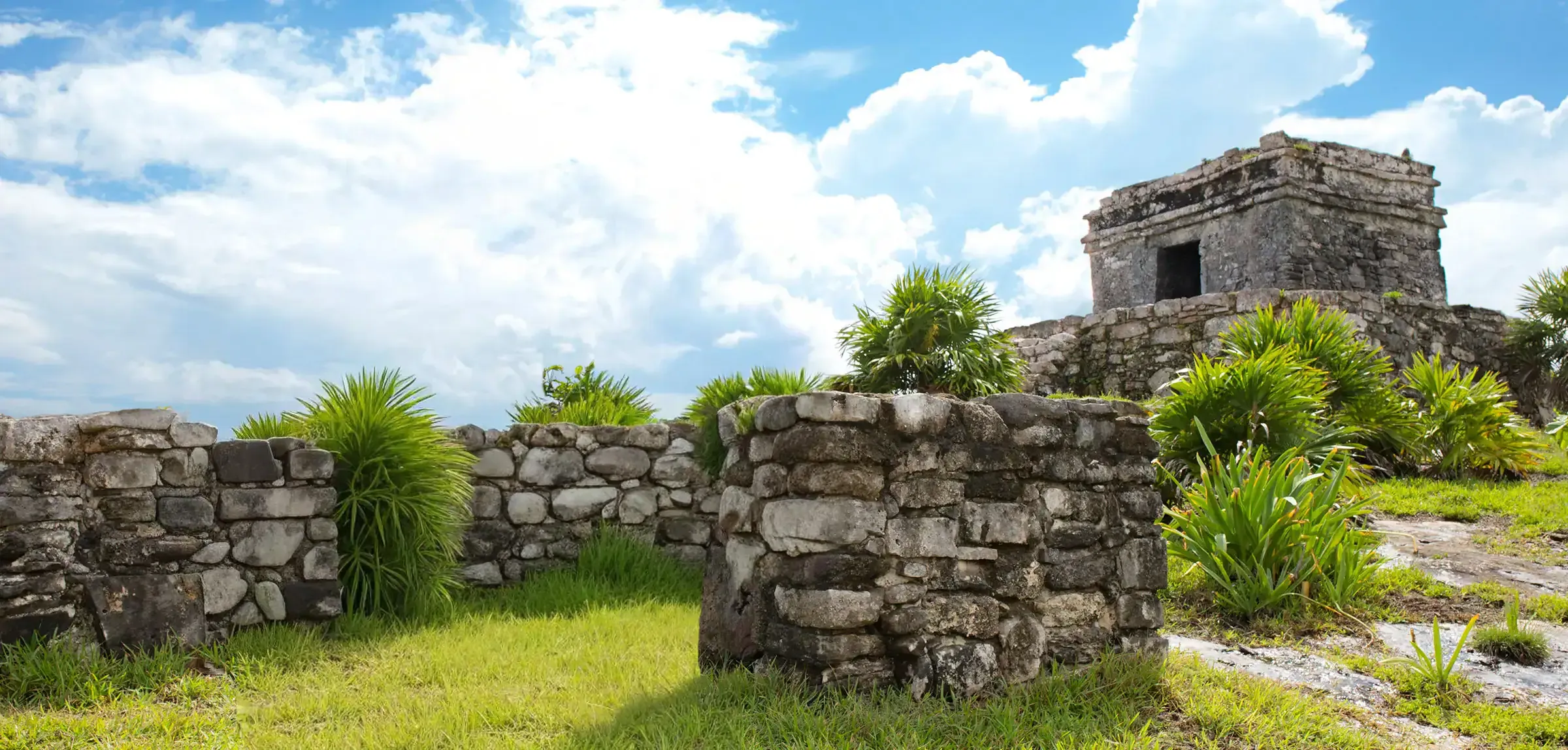 Estructuras de la zona arqueológica de Tulum rodeadas de vegetación
